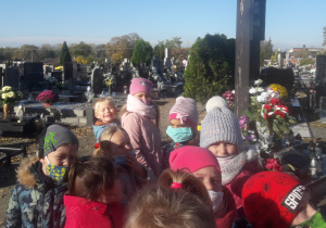 Dzieci stoją na cmentarzu.